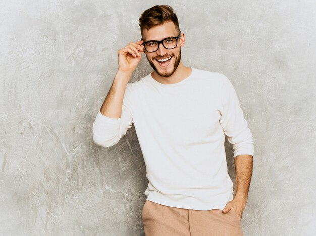 Ritratto del modello sorridente bello dell'uomo d'affari dei pantaloni a vita bassa che indossa i vestiti bianchi casuali di estate.