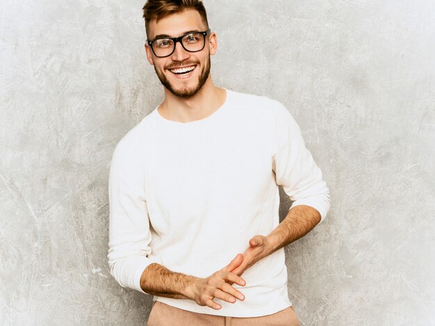 Ritratto del modello sorridente bello dell'uomo d'affari dei pantaloni a vita bassa che indossa i vestiti bianchi casuali di estate.