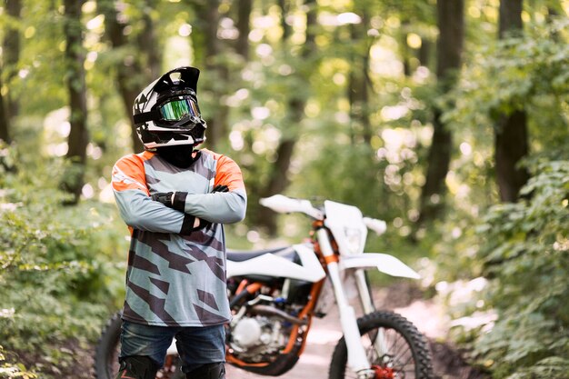 Ritratto del motociclista in posa nella foresta