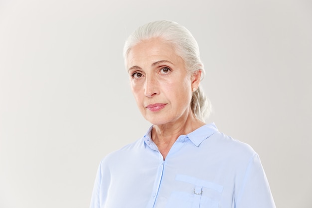 Ritratto del primo piano di bella donna anziana in camicia blu