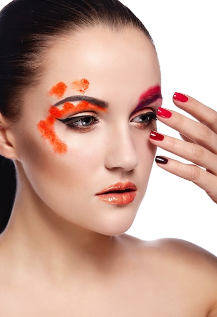 Ritratto del primo piano di look.glamor di alta moda di bello modello sexy della giovane donna castana con le labbra arancio e pelle pulita perfetta con le unghie variopinte