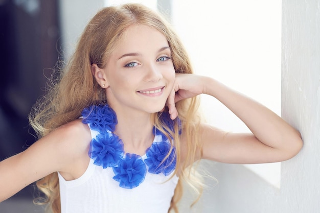 Ritratto del primo piano di un modello di bambina felice con un sorriso affascinante che posa in uno studio.