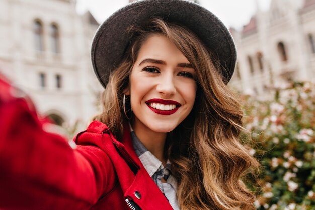 Ritratto del primo piano di una donna meravigliosa con capelli castano chiaro che fa selfie durante il viaggio