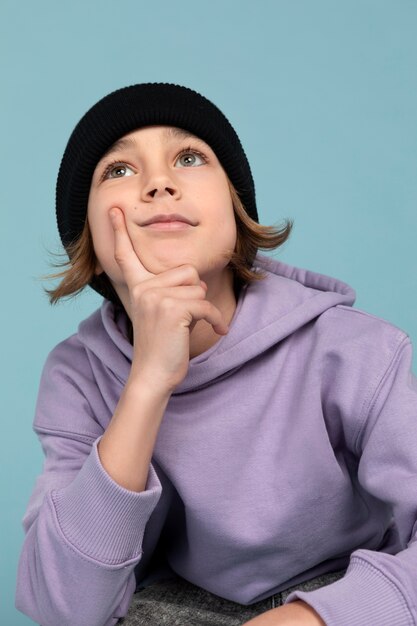 Ritratto del ragazzo teenager che posa e che pensa