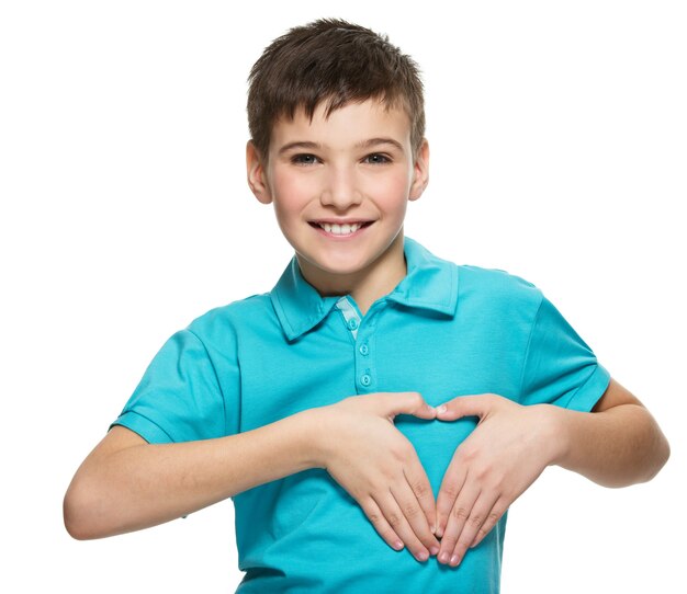 Ritratto del ragazzo teenager felice con una forma del cuore isolata su bianco