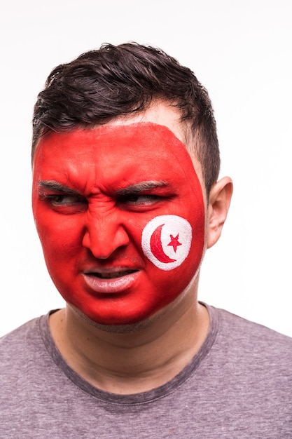 Ritratto del viso di tifoso felice squadra nazionale tunisina con faccia dipinta isolato su sfondo bianco