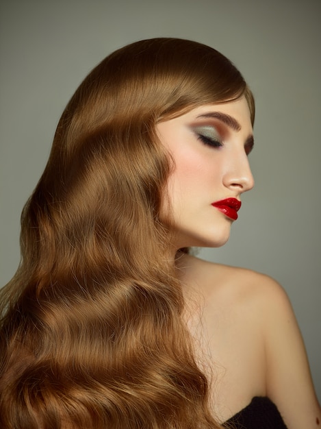 Ritratto dell'interno del primo piano della ragazza adorabile con capelli variopinti. Graziosa giovane donna con un lungo taglio di capelli