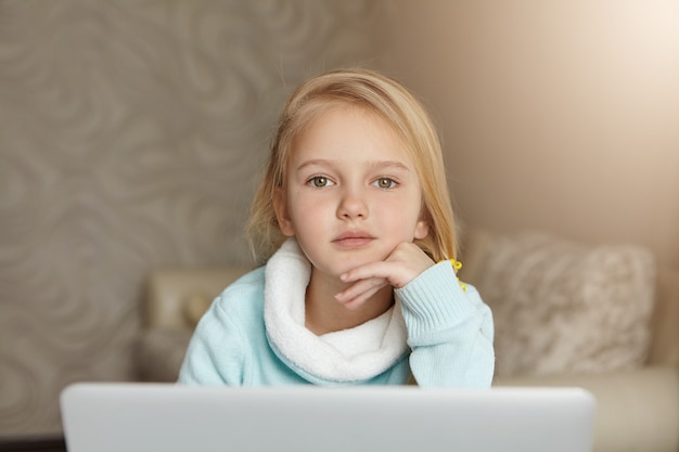 Ritratto dell'interno della bambina europea sveglia adorabile con capelli biondi