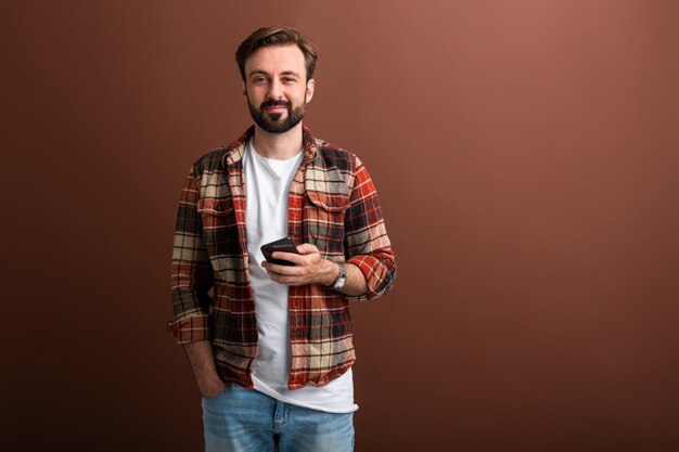 Ritratto dell'uomo barbuto alla moda bello su colore marrone