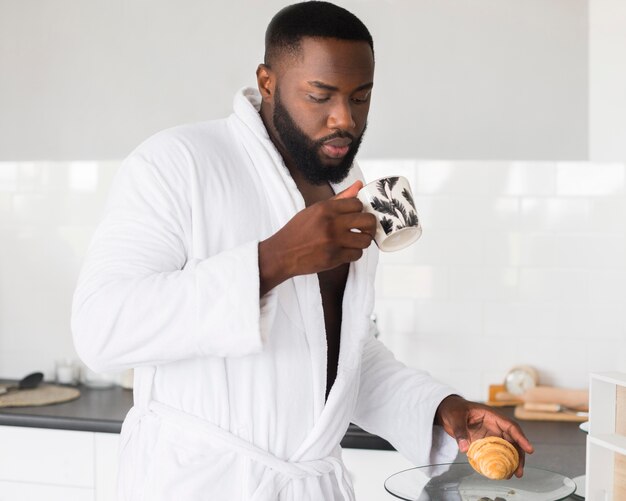 Ritratto dell'uomo che mangia caffè di mattina