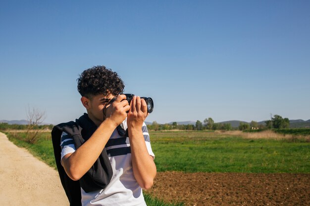 Ritratto dell&#39;uomo che prende fotografando con la macchina fotografica digitale