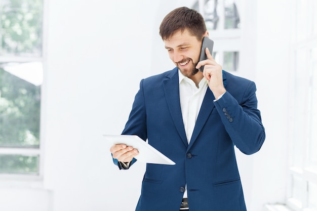 Ritratto dell'uomo d'affari che parla sul telefono in ufficio