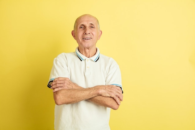 Ritratto dell'uomo maggiore caucasico isolato su studio giallo