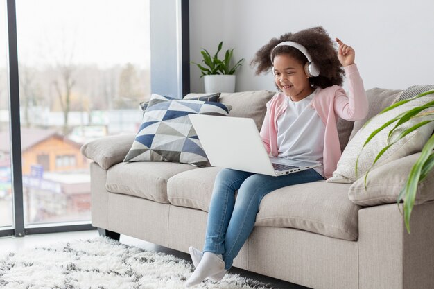 Ritratto della bambina adorabile che ascolta la musica a casa