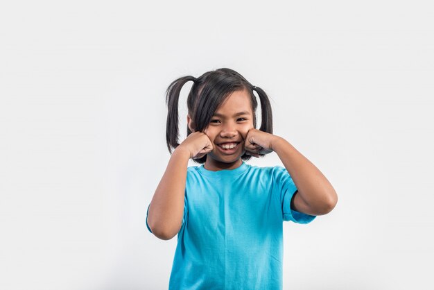 Ritratto della bambina divertente che agisce nel colpo dello studio