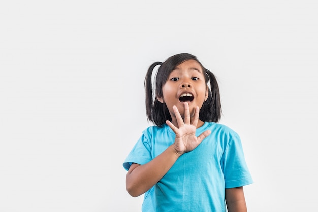 Ritratto della bambina divertente che agisce nel colpo dello studio