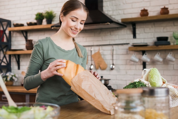 Ritratto della donna che ottiene pane dalla borsa