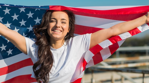 Ritratto della donna che tiene le grandi bandiere degli SUA