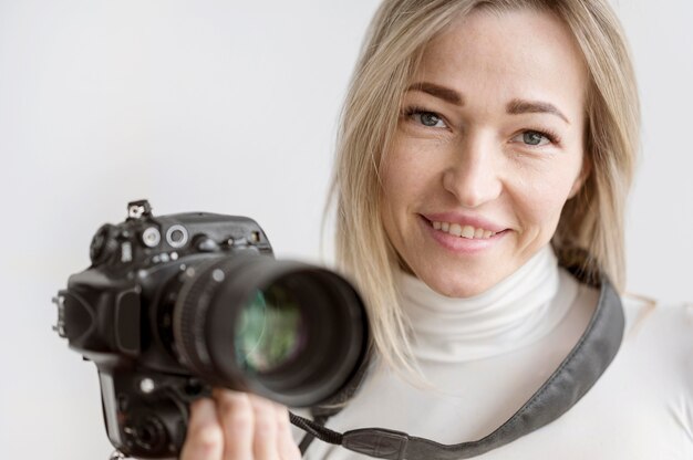 Ritratto della donna che tiene una foto della macchina fotografica