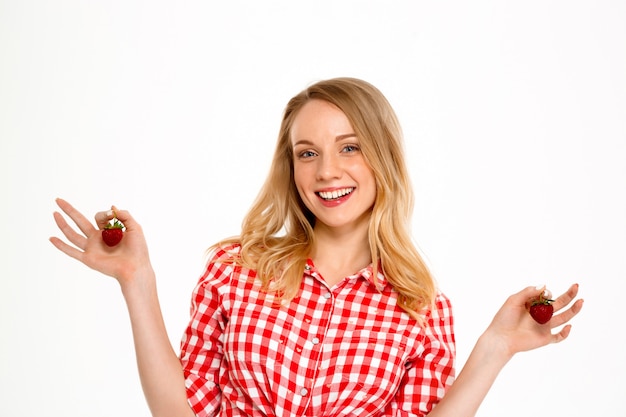 Ritratto della donna del paese con la fragola su bianco.