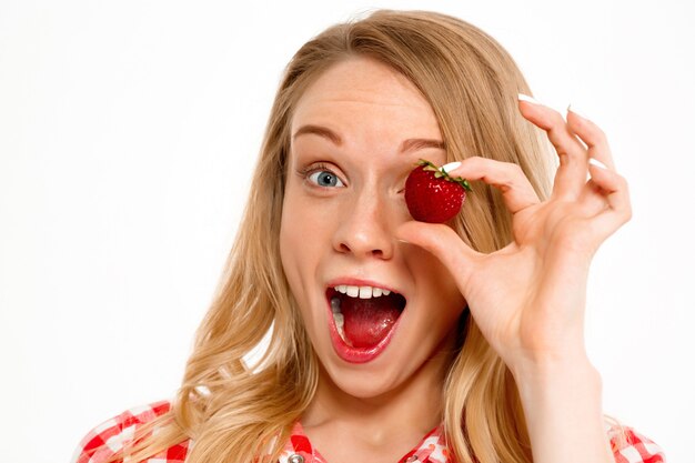 Ritratto della donna del paese con la fragola su bianco.