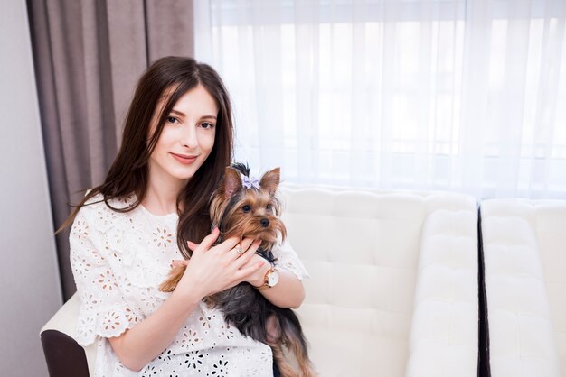 Ritratto della donna moderna a casa con il cane