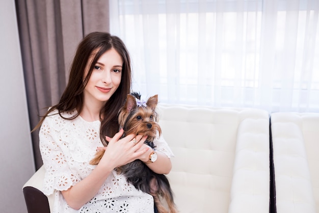 Ritratto della donna moderna a casa con il cane