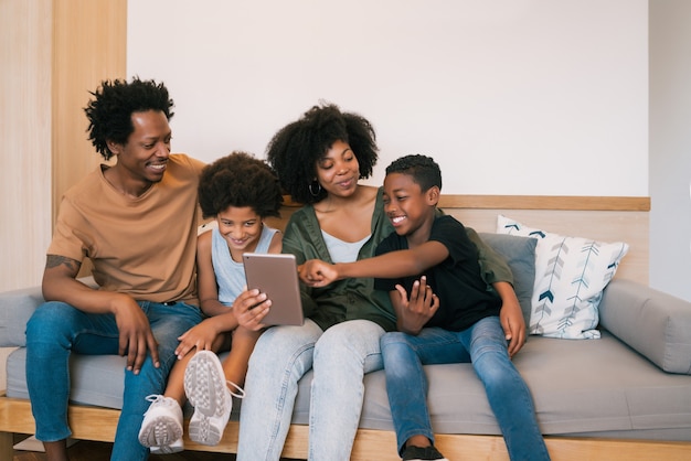 Ritratto della famiglia afroamericana che prende un selfie insieme alla tavoletta digitale a casa. Concetto di famiglia e stile di vita.