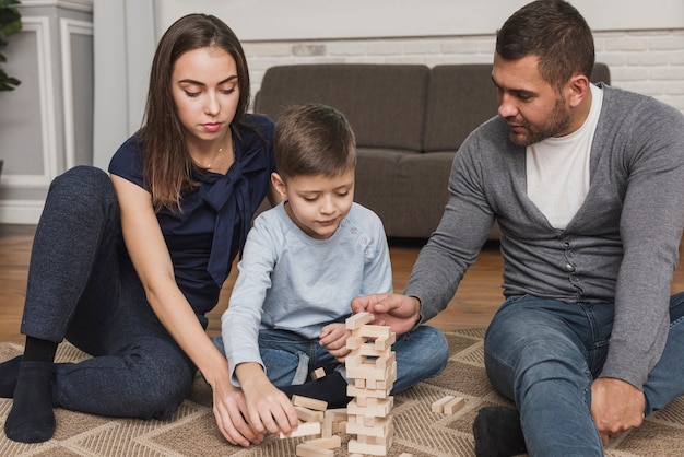 Ritratto della famiglia che gioca insieme jenga