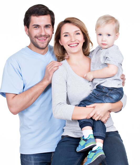 Ritratto della famiglia felice con il bambino piccolo che guarda l'obbiettivo - isolato