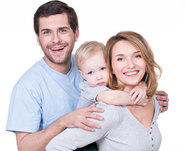Ritratto della famiglia felice con il bambino piccolo che guarda l'obbiettivo - isolato