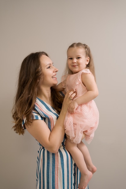 Ritratto della figlia e della madre su fondo beige