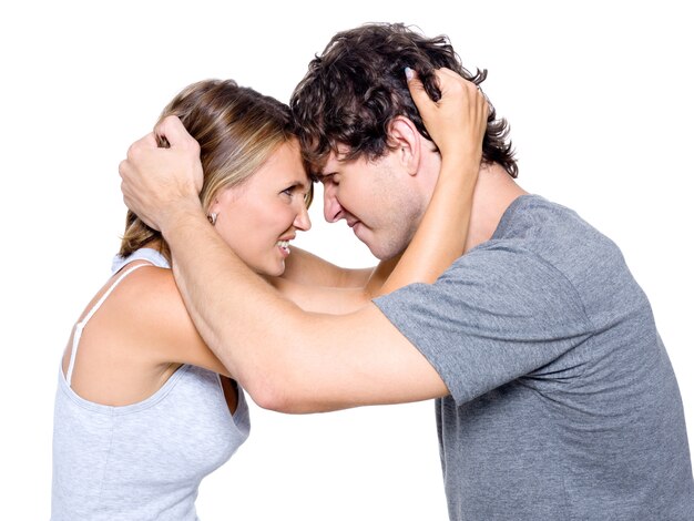 Ritratto della giovane coppia arrabbiata isolata su sfondo bianco
