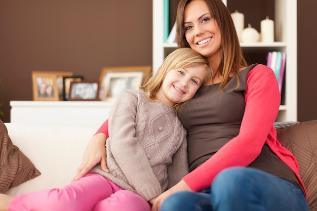 Ritratto della madre amorevole con la figlia sul divano