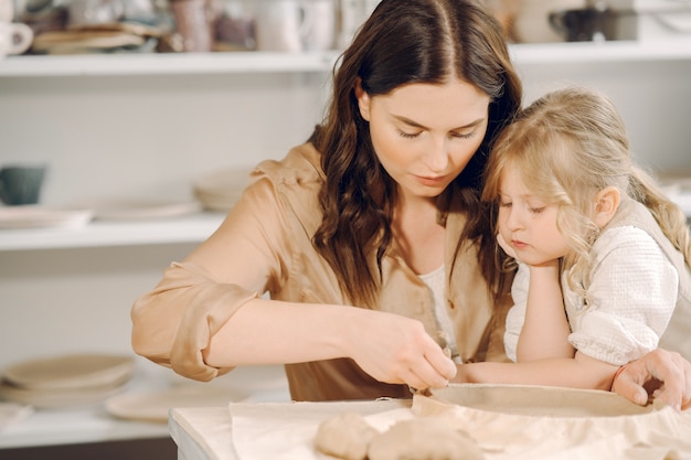 Ritratto della madre e della bambina che modellano insieme argilla