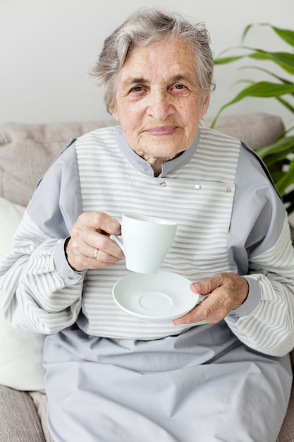 Ritratto della nonna che gode della tazza di caffè