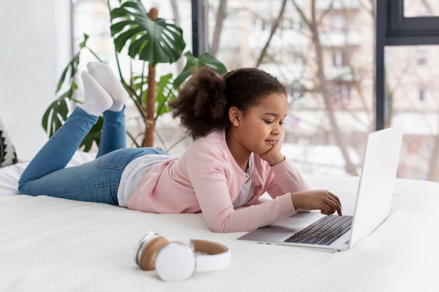 Ritratto della ragazza che per mezzo del computer portatile