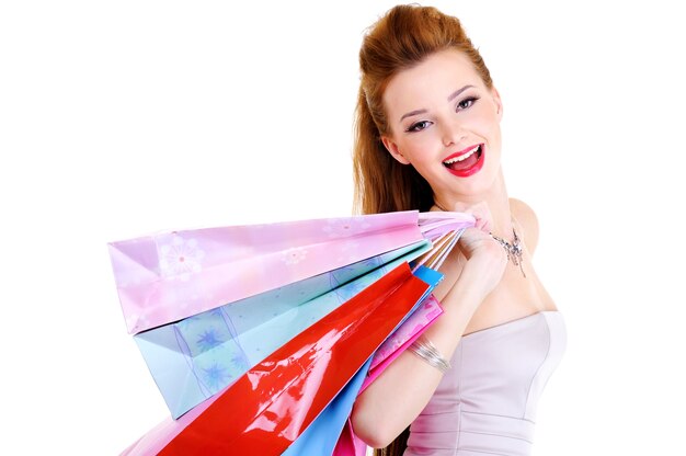 Ritratto della ragazza che ride felice con gli acquisti nelle mani dopo una passeggiata in negozio