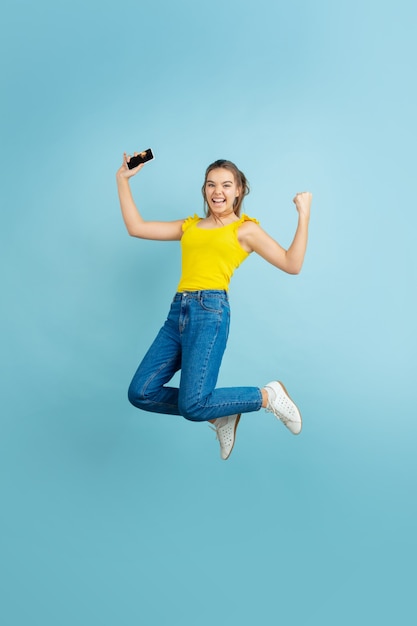 Ritratto della ragazza teenager caucasica su priorità bassa blu. Bellissima modella capelli lunghi in casual.