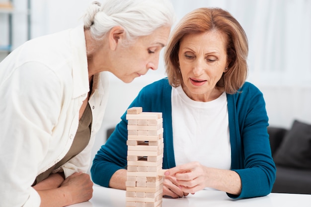 Ritratto delle donne sveglie che giocano jenga