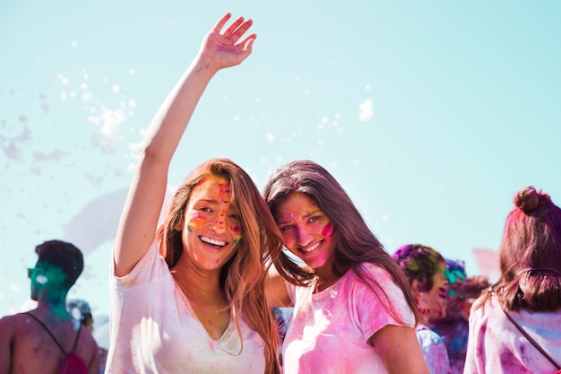 Ritratto delle giovani donne sorridenti che godono del festival di holi