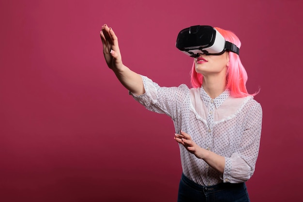 Ritratto di adulto felice con i capelli rosa che gioca con gli occhiali vr, utilizzando un gadget di simulazione interattivo 3d. Goditi la realtà aumentata delle cuffie wireless con una visione elettronica futuristica.