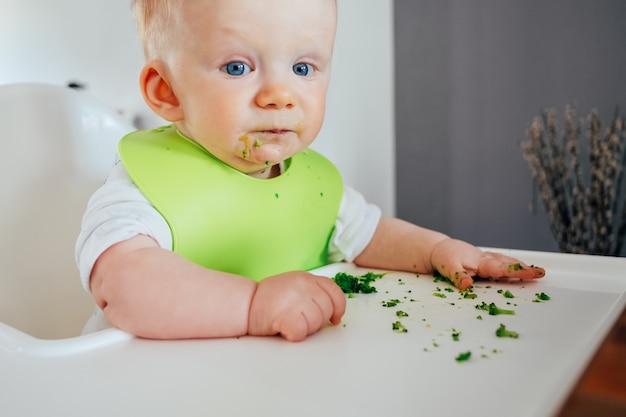 Ritratto di bambina carina seduta disordinata dopo l'alimentazione