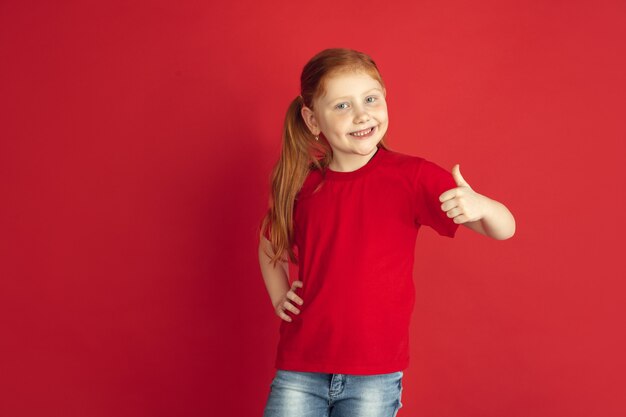 Ritratto di bambina caucasica isolato su muro rosso