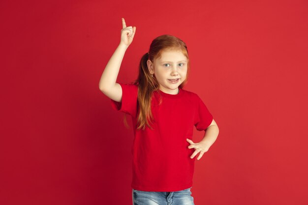 Ritratto di bambina caucasica isolato su muro rosso