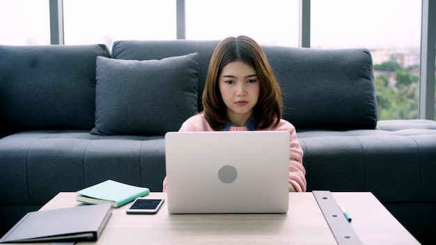 Ritratto di bella attraente giovane donna asiatica sorridente utilizzando computer o laptop