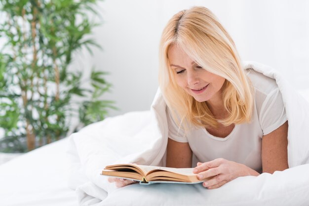 Ritratto di bella donna adulta che legge un libro