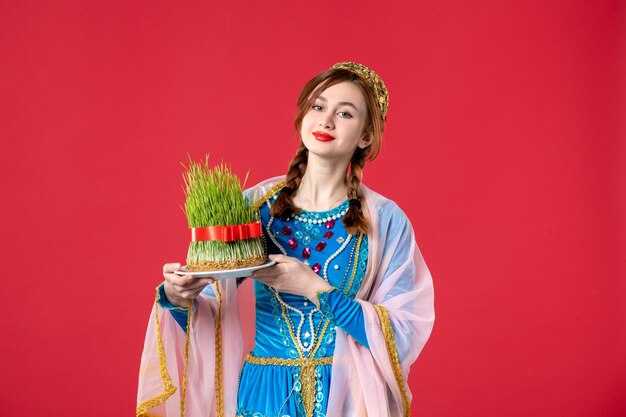 Ritratto di bella donna azera in abito tradizionale con semeni su rosso