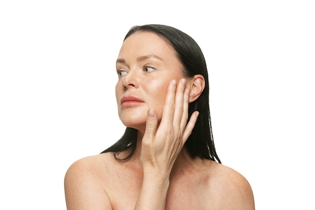 Ritratto di bella donna che applica crema idratante viso isolato oevr sfondo bianco Cosmetologia