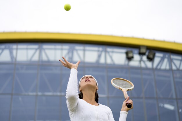 Ritratto di bella donna che gioca a tennis all&#39;aperto